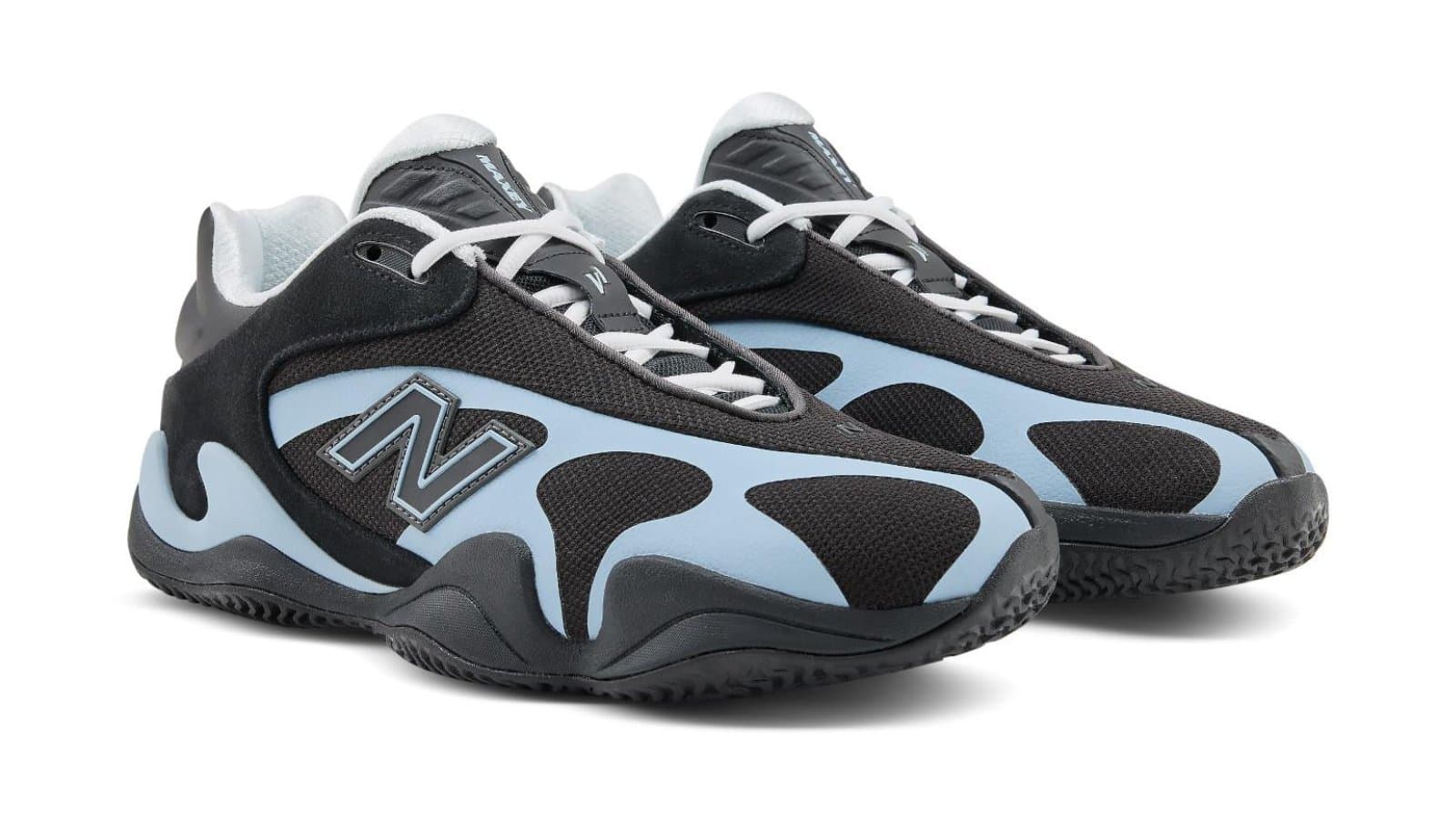 New Balance Maxey v1 colorway nero e blu su superficie da pallacanestro, fotografia editoriale