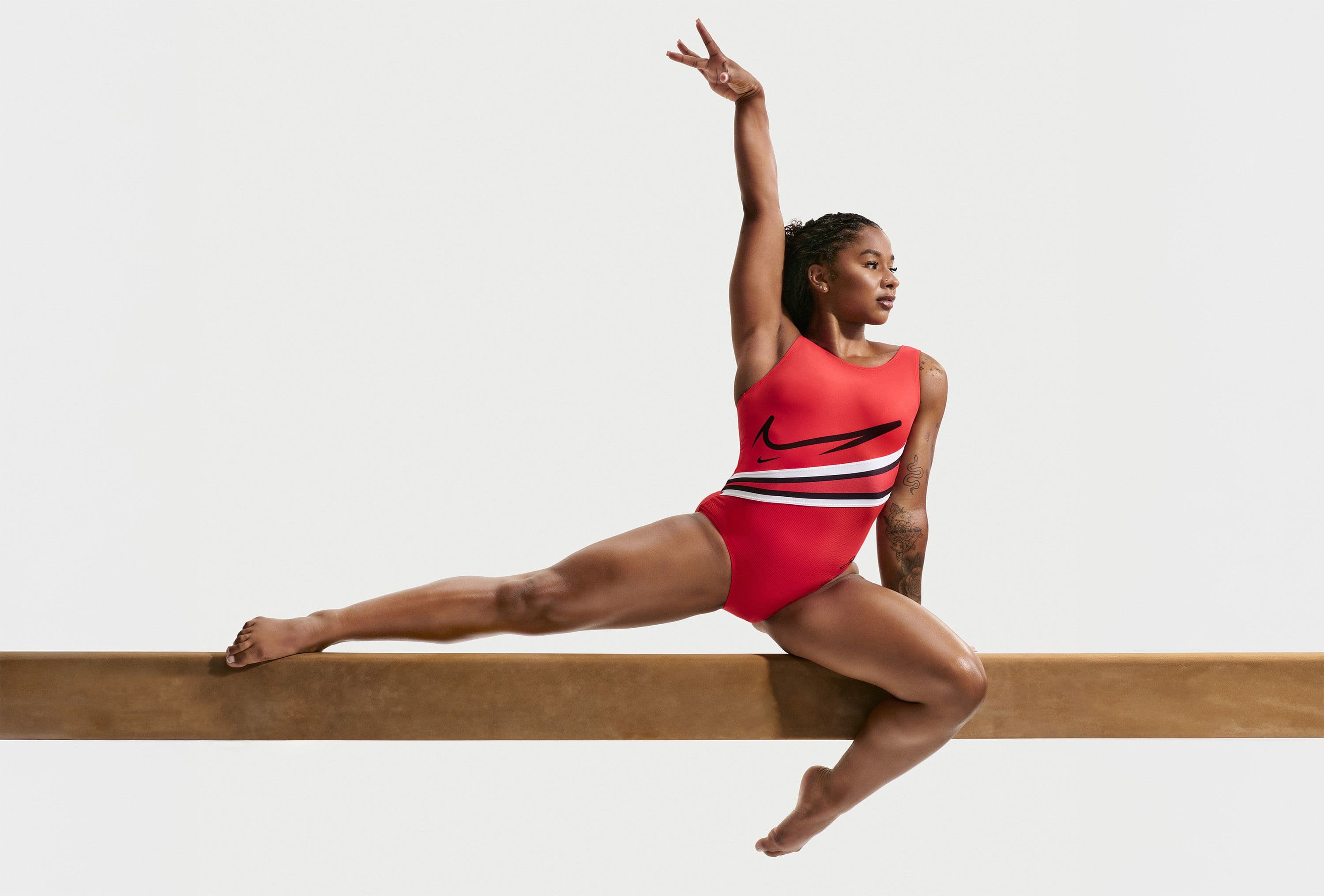 Body da ginnastica artistica con design grafico audace su sfondo neutro, illuminazione editoriale