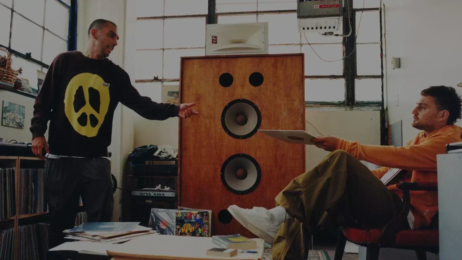 Altoparlante vintage fatto a mano in uno studio creativo di Brooklyn con una sneaker bianca classica in primo piano